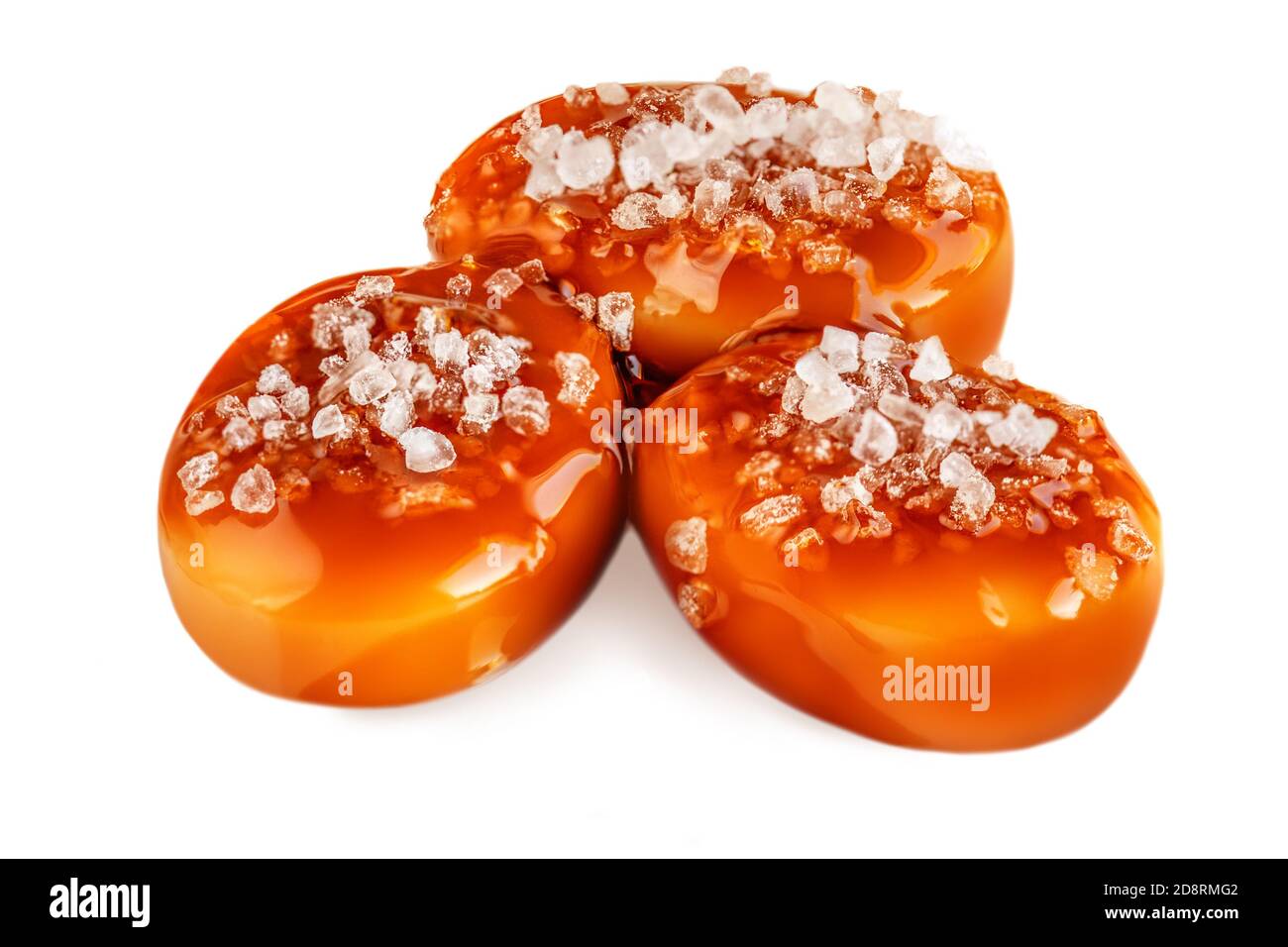 Süße Bonbons mit salzigen Karamell Belag isoliert auf weißem Hintergrund. Toffee mit Karamellsauce Makro Stockfoto