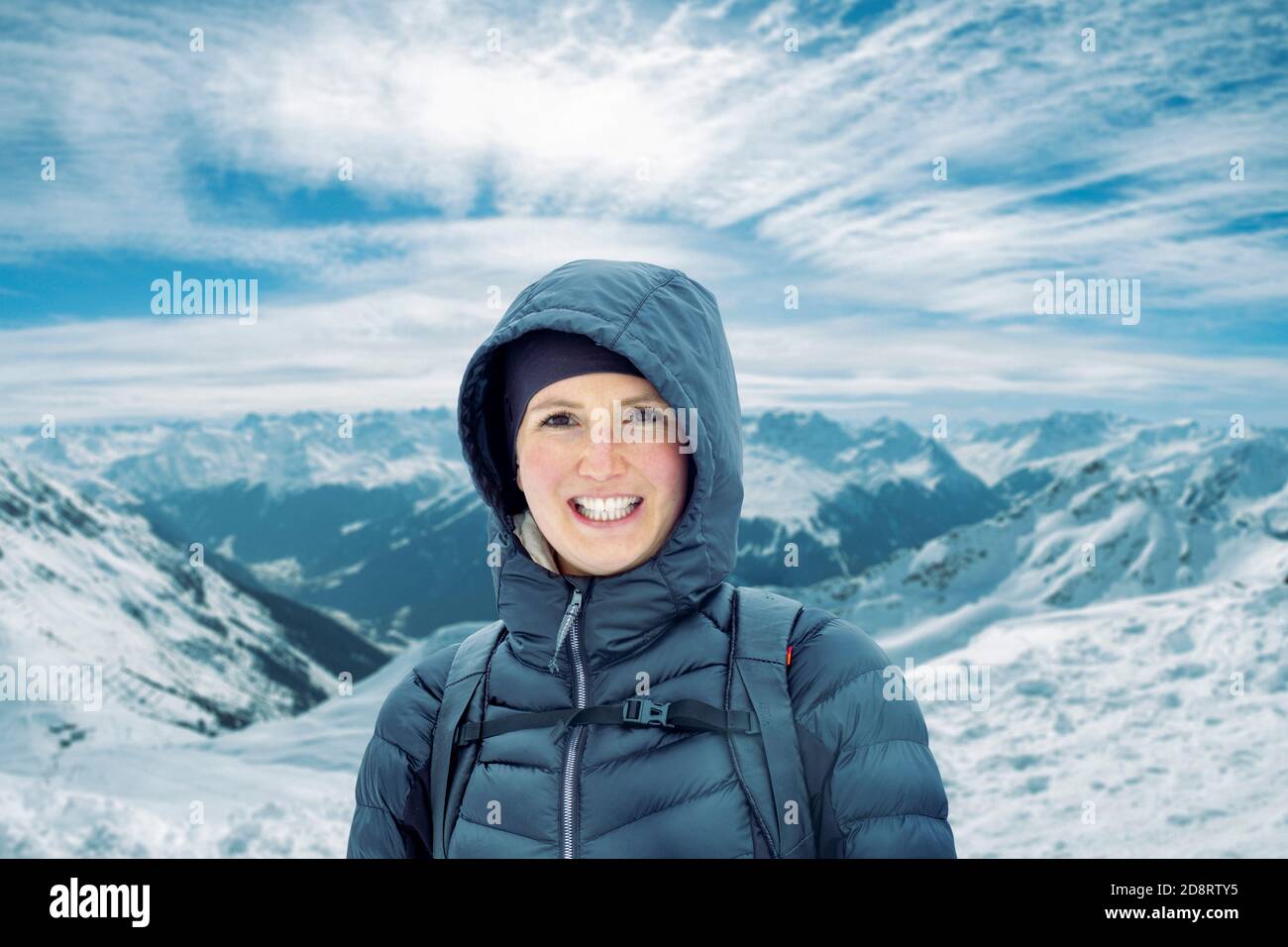 Natürlich aussehende junge Frau steht vor einem Berg Und lächelt an der Kamera Stockfoto