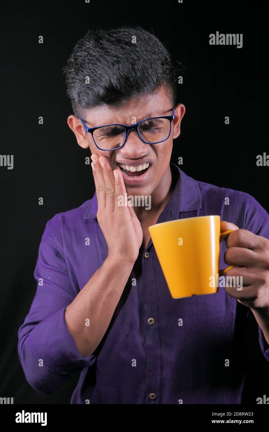 Junger Mann mit empfindlichen Zähnen und Glas kaltem Wasser. Stockfoto