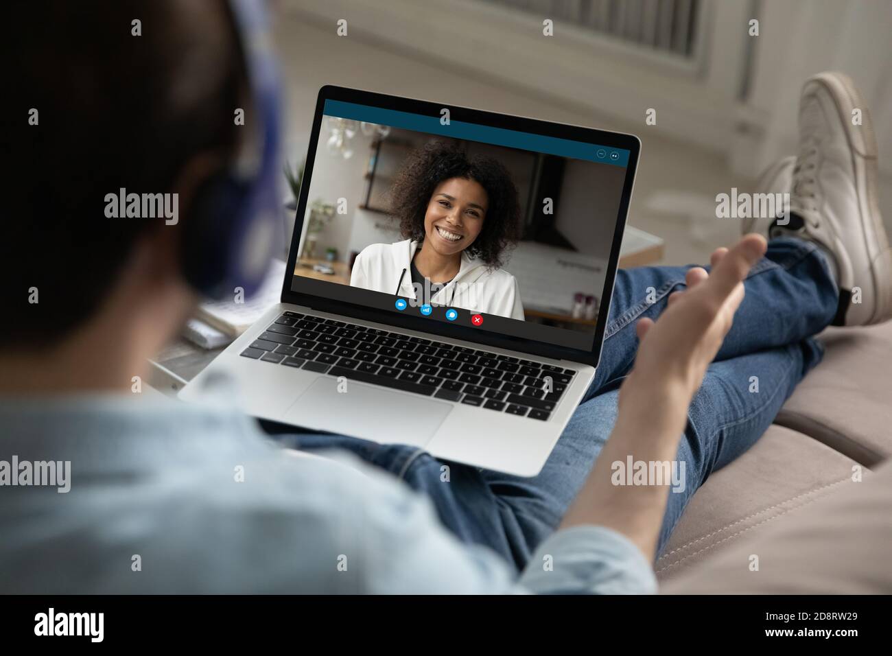 Rückansicht Mann trägt Kopfhörer und chattet mit lächelnder Frau online Stockfoto