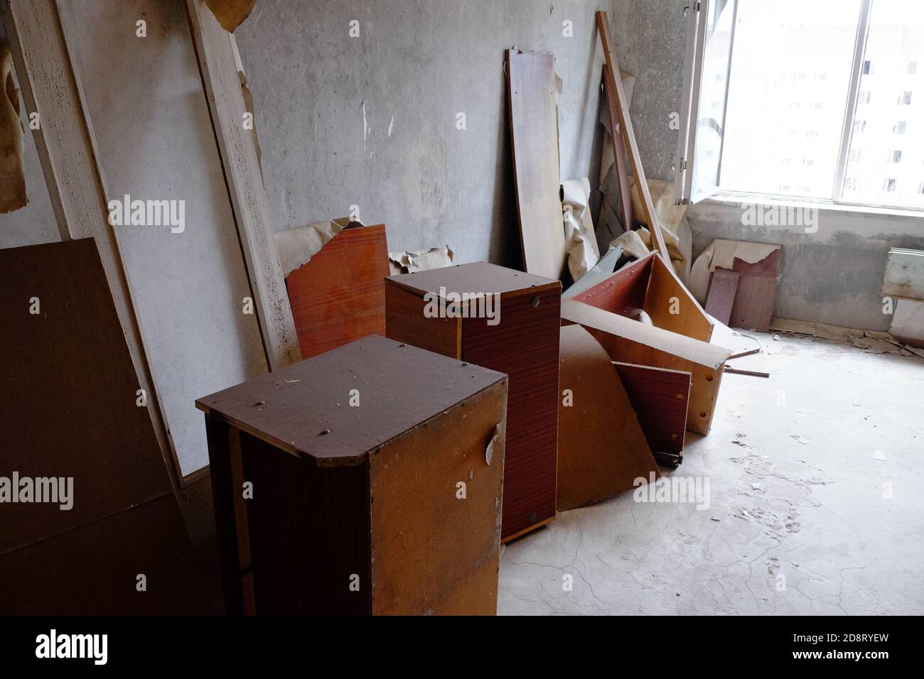 Alte Möbel streuten sich über ein Zimmer in einer verlassenen Wohnung in der Geisterstadt Pripyat. Stockfoto