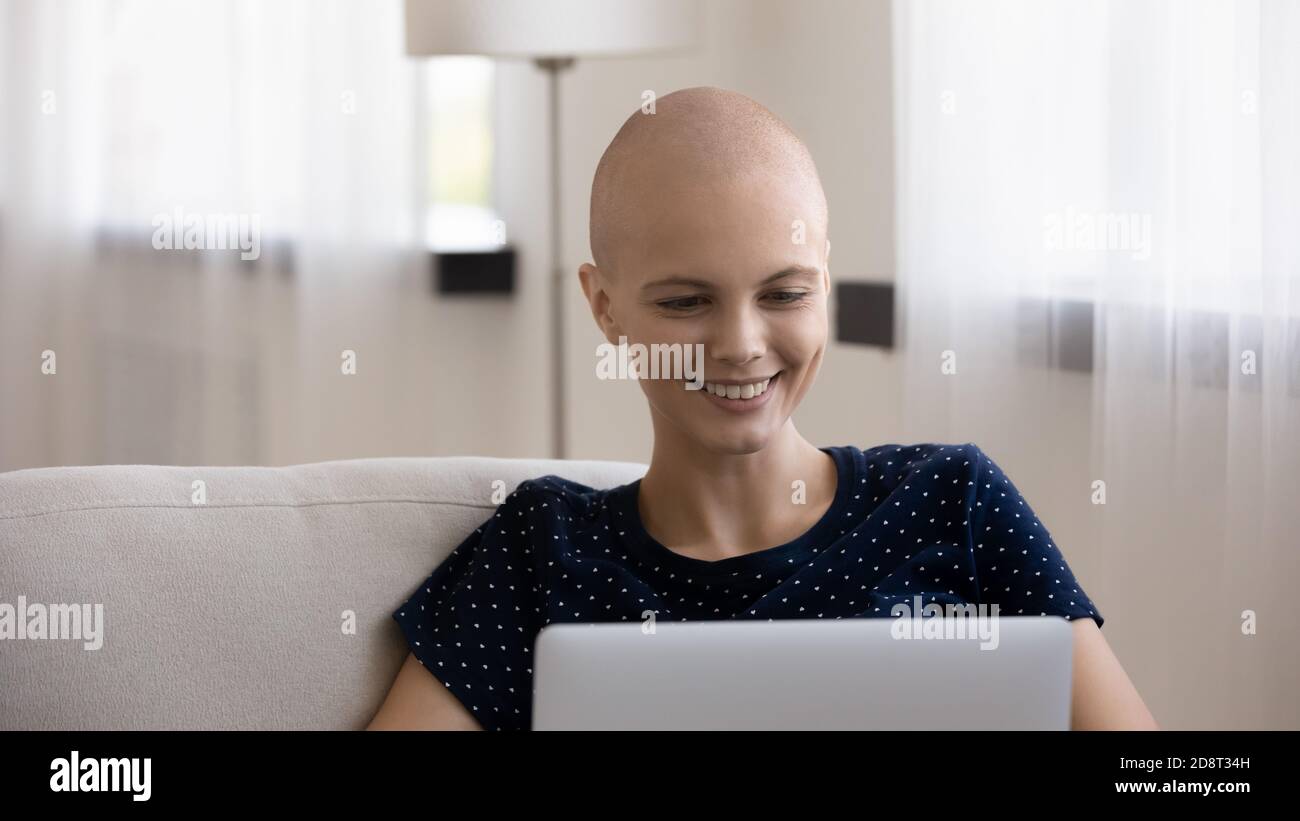 Nahaufnahme Kopfschuss lächelnde haarlose Frau mit Laptop Stockfoto