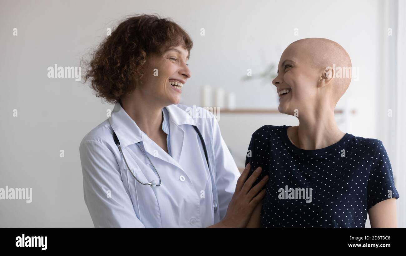 Nahaufnahme überglücklich Arzt und haarlose Frau lachen, feiern Erfolg Stockfoto