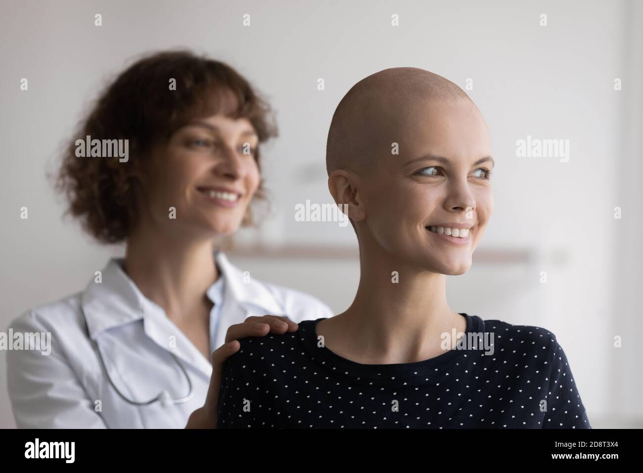 Nahaufnahme lächelnde haarlose Frau mit Arzt, der zur Seite schaut Stockfoto