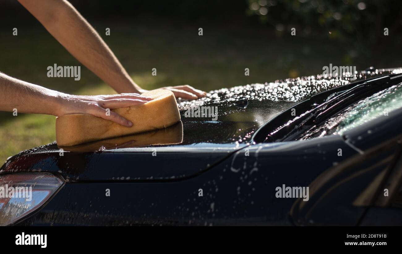 Nahaufnahme eines Mannes, der ein neues Auto wascht Stockfoto