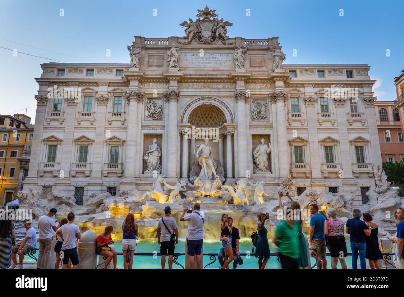 Stadt Rom, Italien, Trevi-Brunnen (Fontana di Trevi) in der Abenddämmerung und Gruppe von Menschen, Touristen genießen den Blick auf das weltberühmte Wahrzeichen Stockfoto