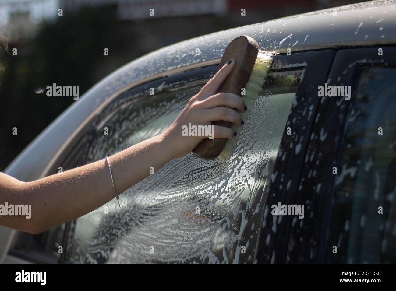 Nahaufnahme einer Frau, die ein Auto wascht Stockfoto