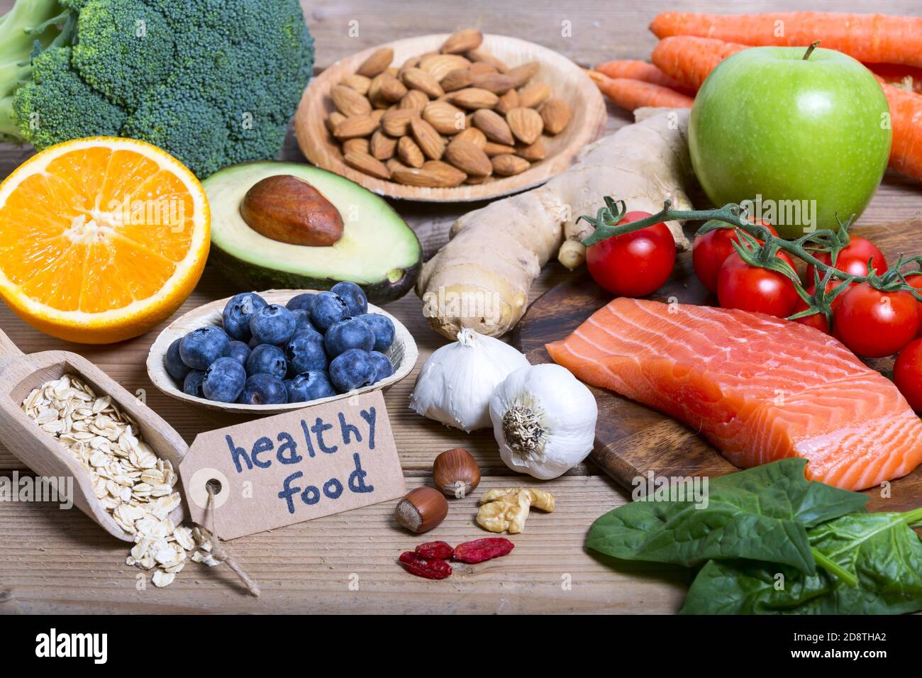 Gesunde Ernährung, saubere Ernährung Auswahl: Obst, Gemüse, Samen, Superfood, Getreide, Blattgemüse auf Holzhintergrund mit Aufschrift 'gesunde Ernährung' Stockfoto