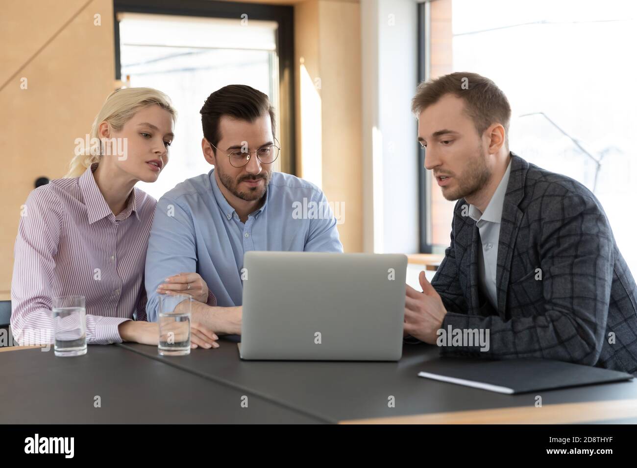 Qualifizierte junge männliche makler zeigt Online-Computer-Präsentation für Kunden. Stockfoto