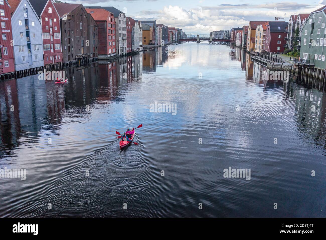 Kajakfahrer auf dem Fluss Nidelva unter den bunten Häusern am Fluss in Trondheim, Norwegen Stockfoto