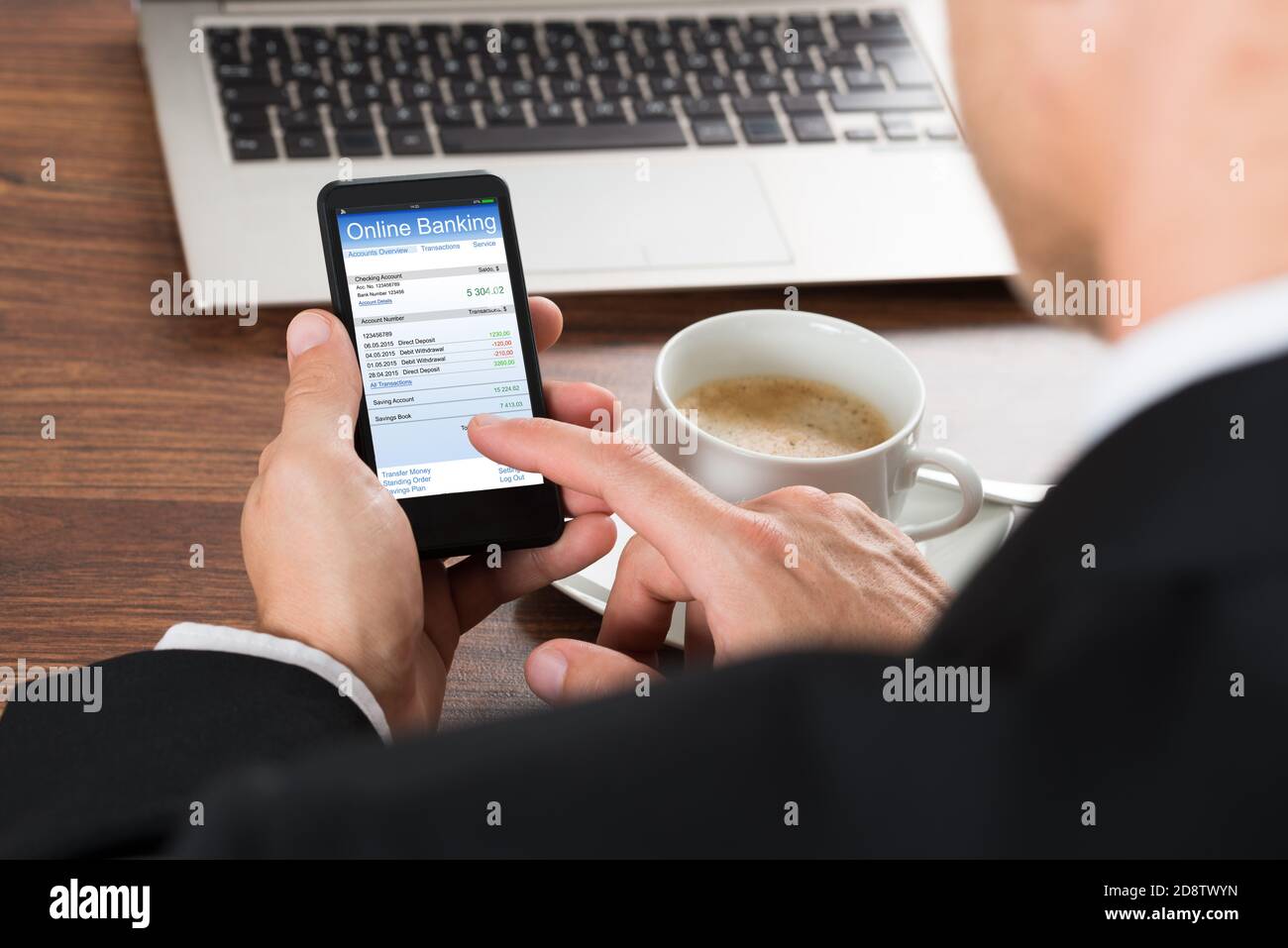Online-Shop mit Handy neben dem Kaffee Stockfoto
