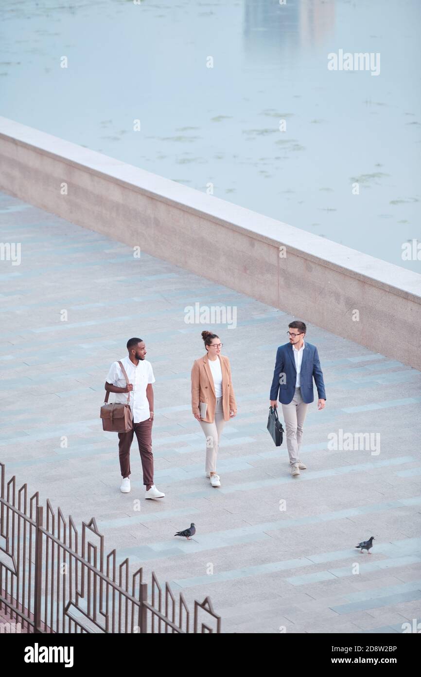 Drei junge Geschäftspartner im Bereich Smart Casualwear diskutieren über Arbeitspunkte Stockfoto