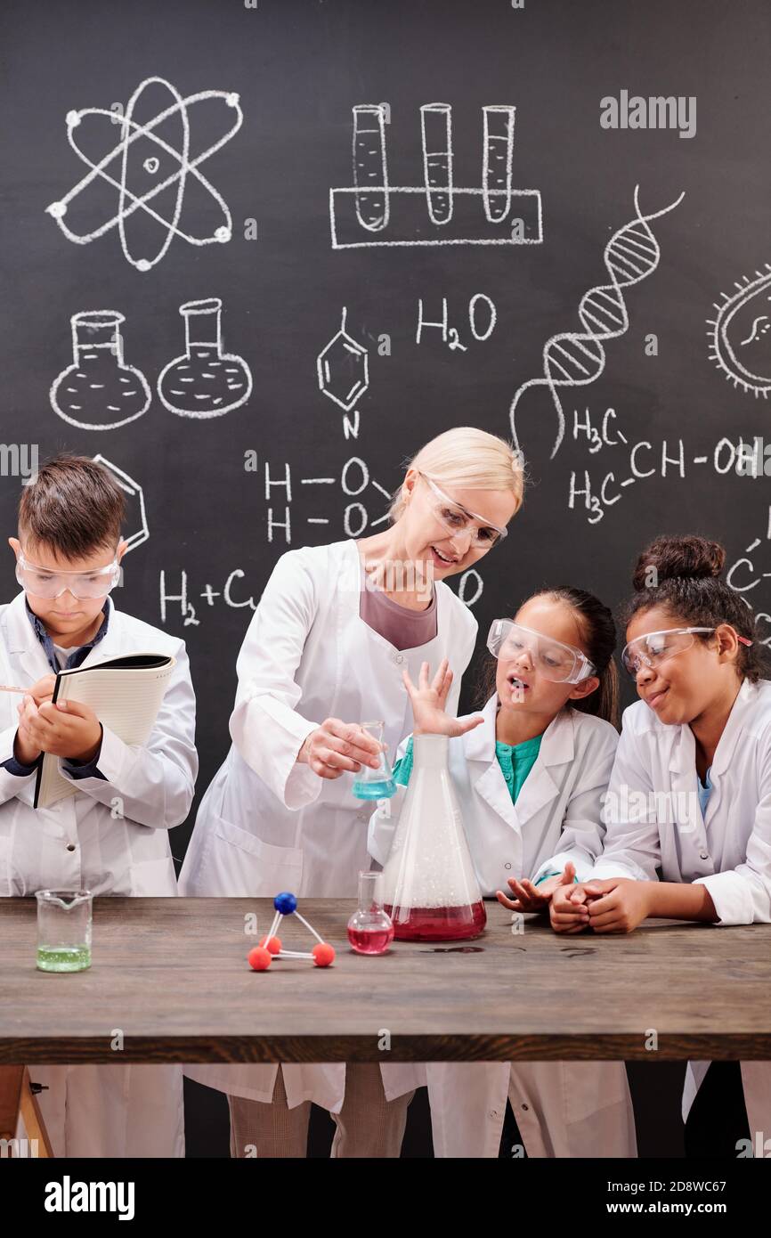 Gruppe von cleveren Schülern der Sekundarstufe beobachten chemische Experiment Stockfoto