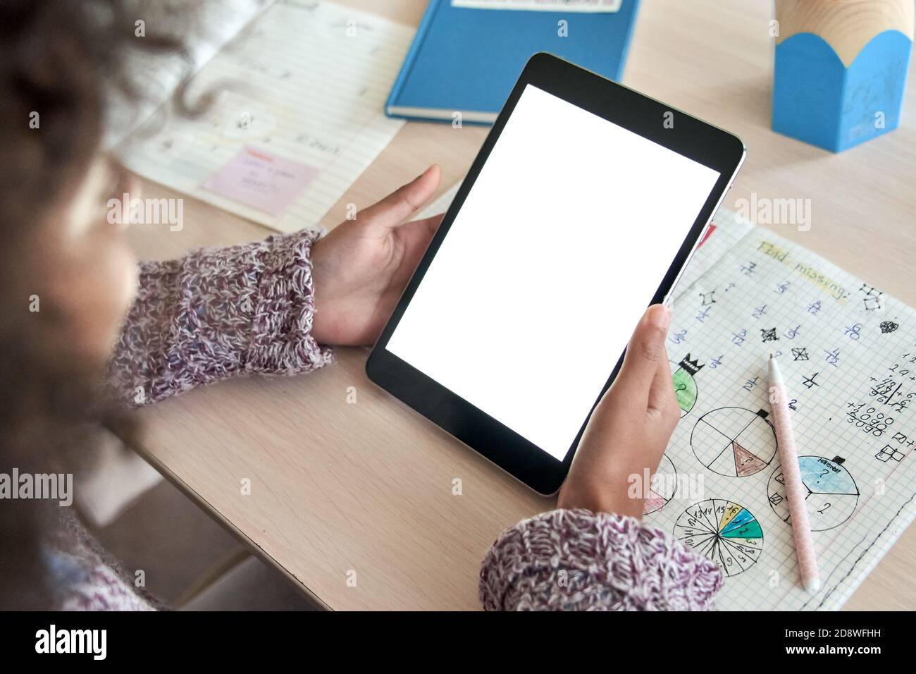 Afrikanisches Mädchen lernen online auf digitalen Tablet. Mockup-Bildschirm über der Schulter. Stockfoto
