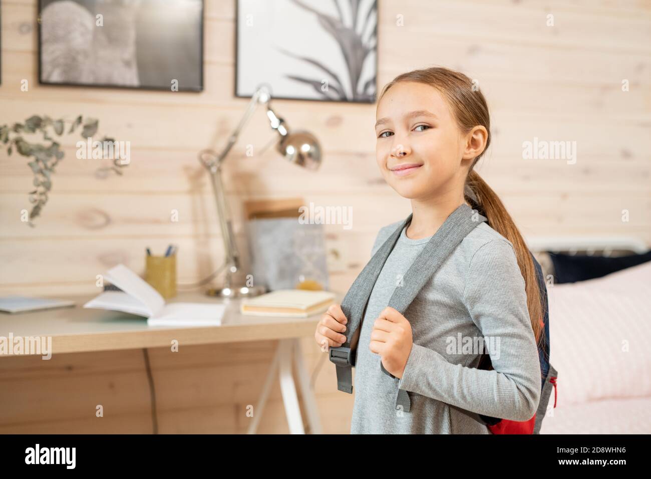 Zeitgenössische glücklich Schulmädchen mit Rucksack vor der Kamera stehen Stockfoto