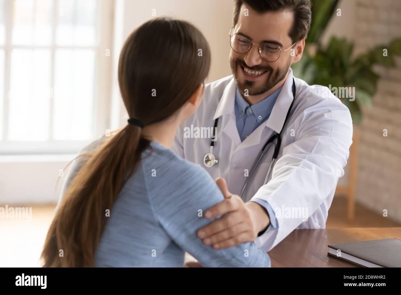 Froh behandelnden Arzt erzählen Frau Patientin über die Erholung der Gesundheit Stockfoto
