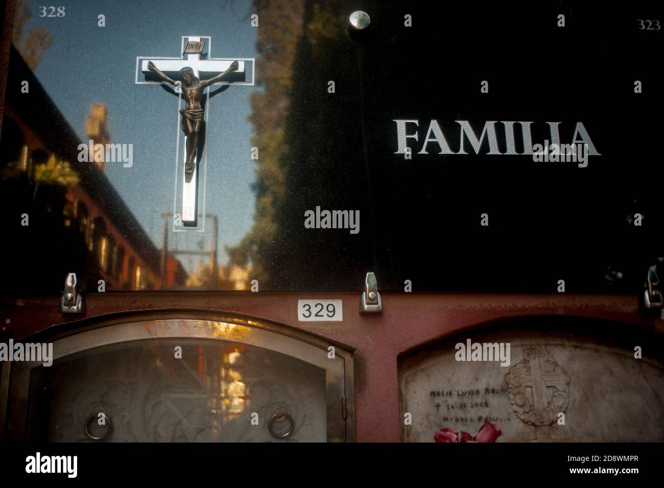 Ein Kruzifix schmückt ein Familiengrab auf dem Sarria Bezirksfriedhof in Barcelona. Stockfoto