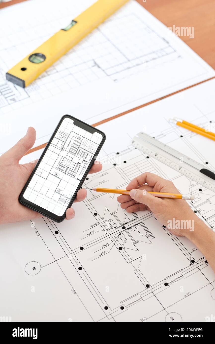 Hände von modernen professionellen Ingenieur oder Architekt mit Bleistift verwenden Smartphone Stockfoto