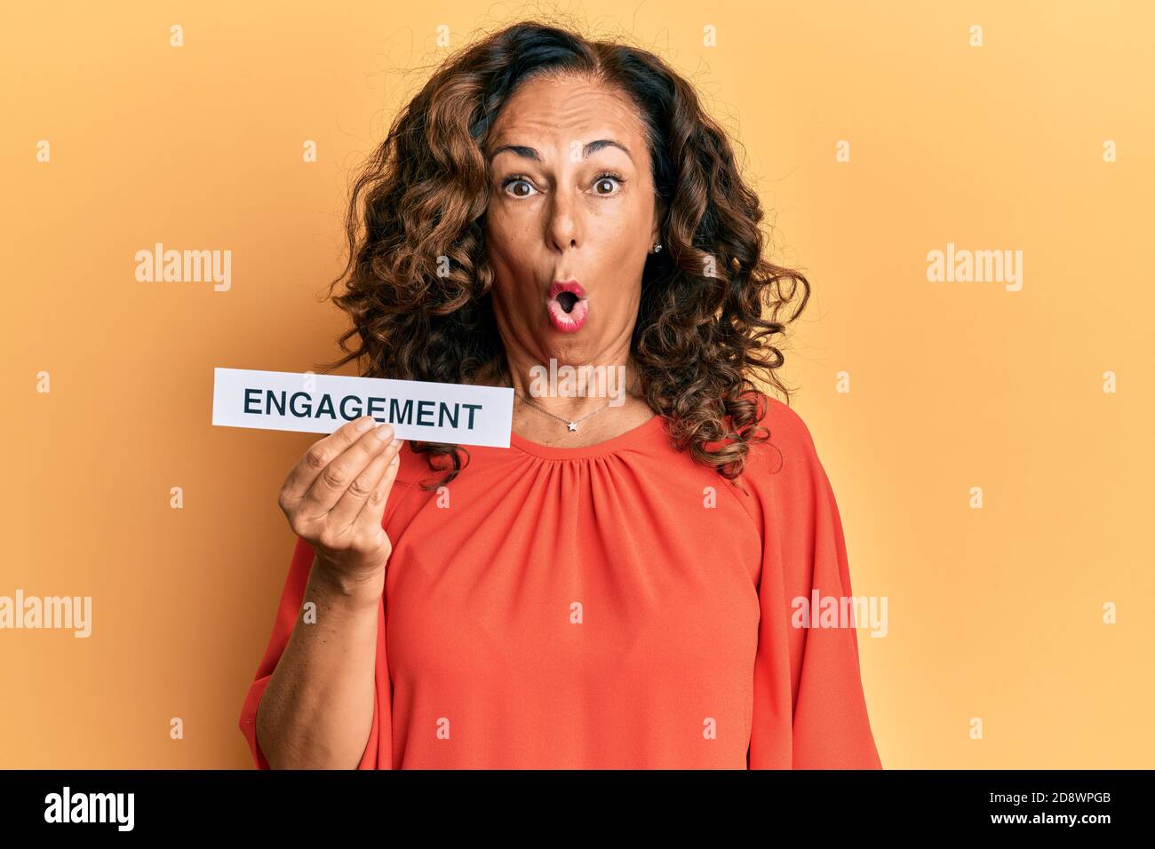 Mittelalter hispanische Frau hält Engagement Wortpapier verängstigt und erstaunt mit offenem Mund für Überraschung, Unglauben Gesicht Stockfoto