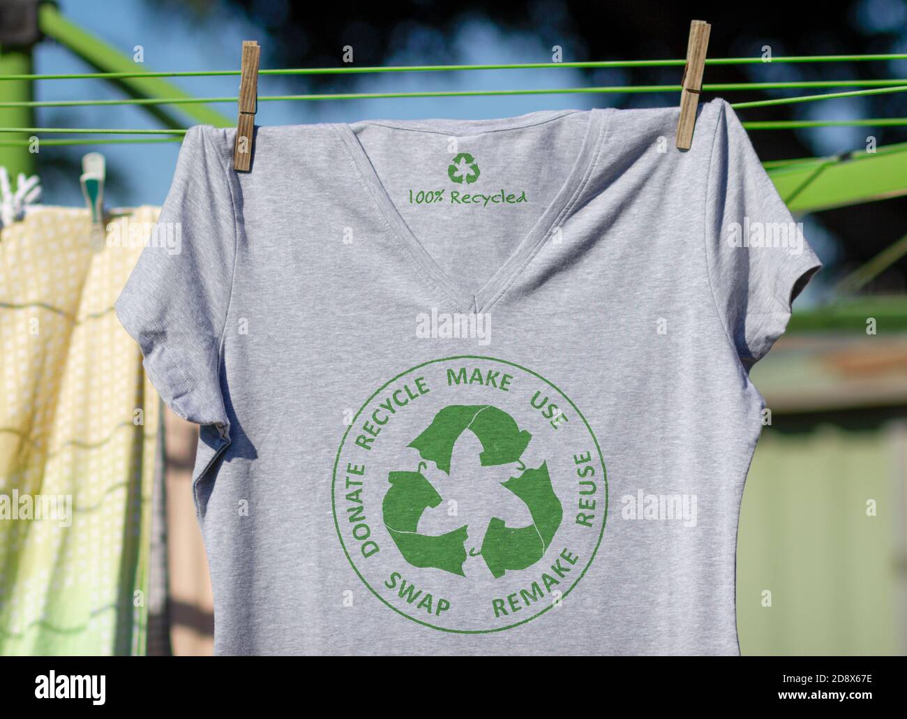 T-Shirt auf Wäscheleine mit kreisförmigen Wirtschaft Textilien Symbol, machen, verwenden, wiederverwenden, tauschen, spenden, recyceln mit Öko-Kleidung recyceln Symbol nachhaltige Mode Stockfoto