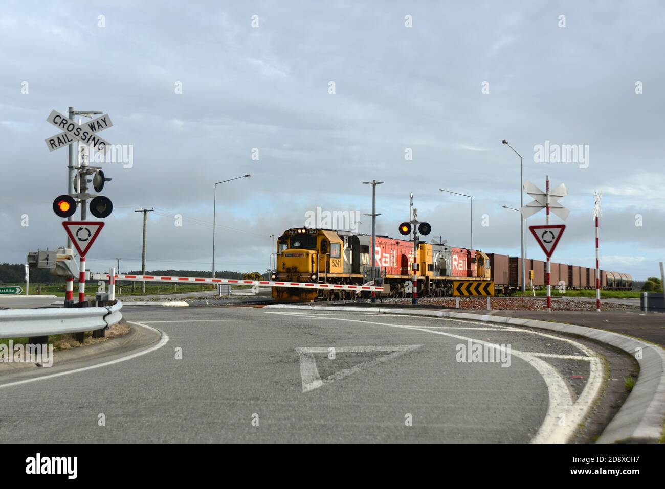 ARAHURA, NEUSEELAND, 29. AUGUST 2020: Ein Güterzug überquert die Hauptstraße in Arahura auf dem State Highway 6. Stockfoto