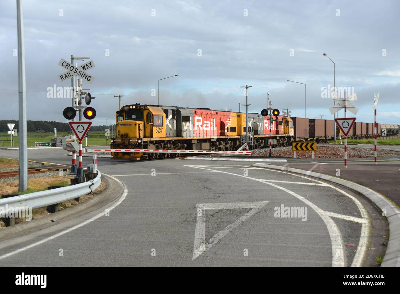 ARAHURA, NEUSEELAND, 29. AUGUST 2020: Ein Güterzug überquert die Hauptstraße in Arahura auf dem State Highway 6. Stockfoto