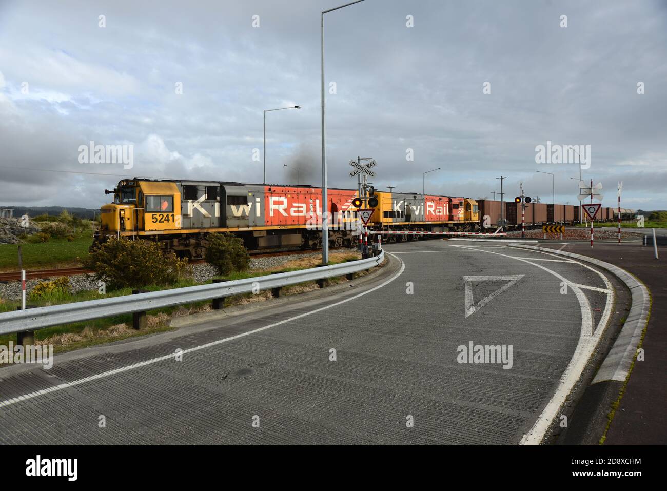 ARAHURA, NEUSEELAND, 29. AUGUST 2020: Ein Güterzug überquert die Hauptstraße in Arahura auf dem State Highway 6. Stockfoto