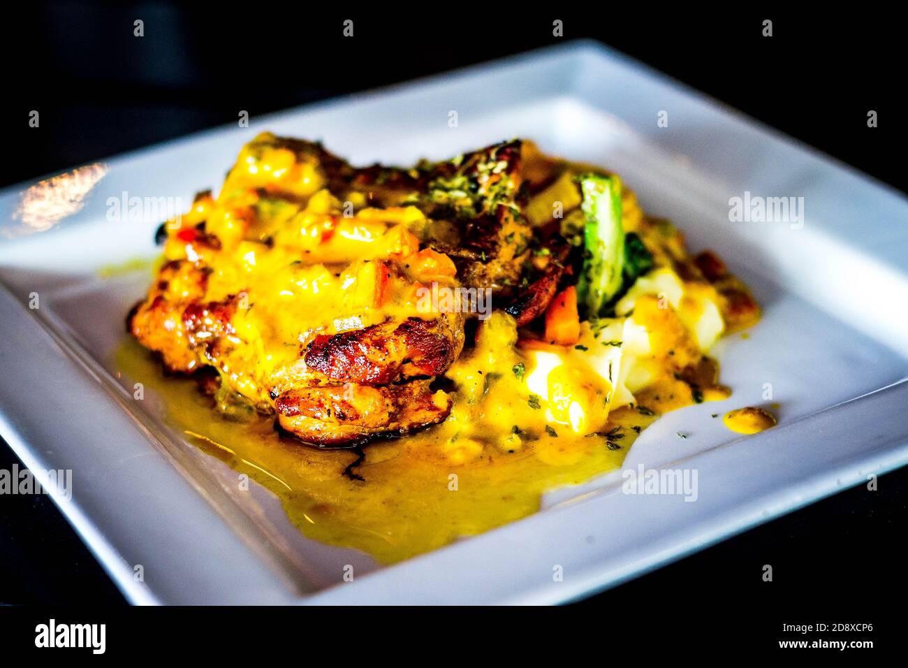 Gegrilltes Hähnchenhacken mit würziger Ananassalsa und Kartoffelpüree Und gegrillte Tomaten Stockfoto