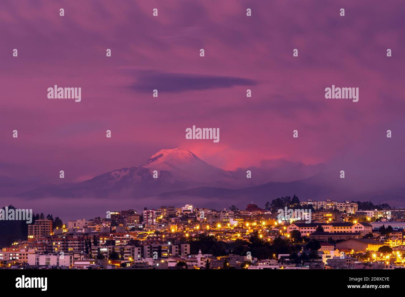 Lila Sonnenuntergang in Quito Stadt mit Cayambe Vulkan im Hintergrund, Ecuador. Stockfoto