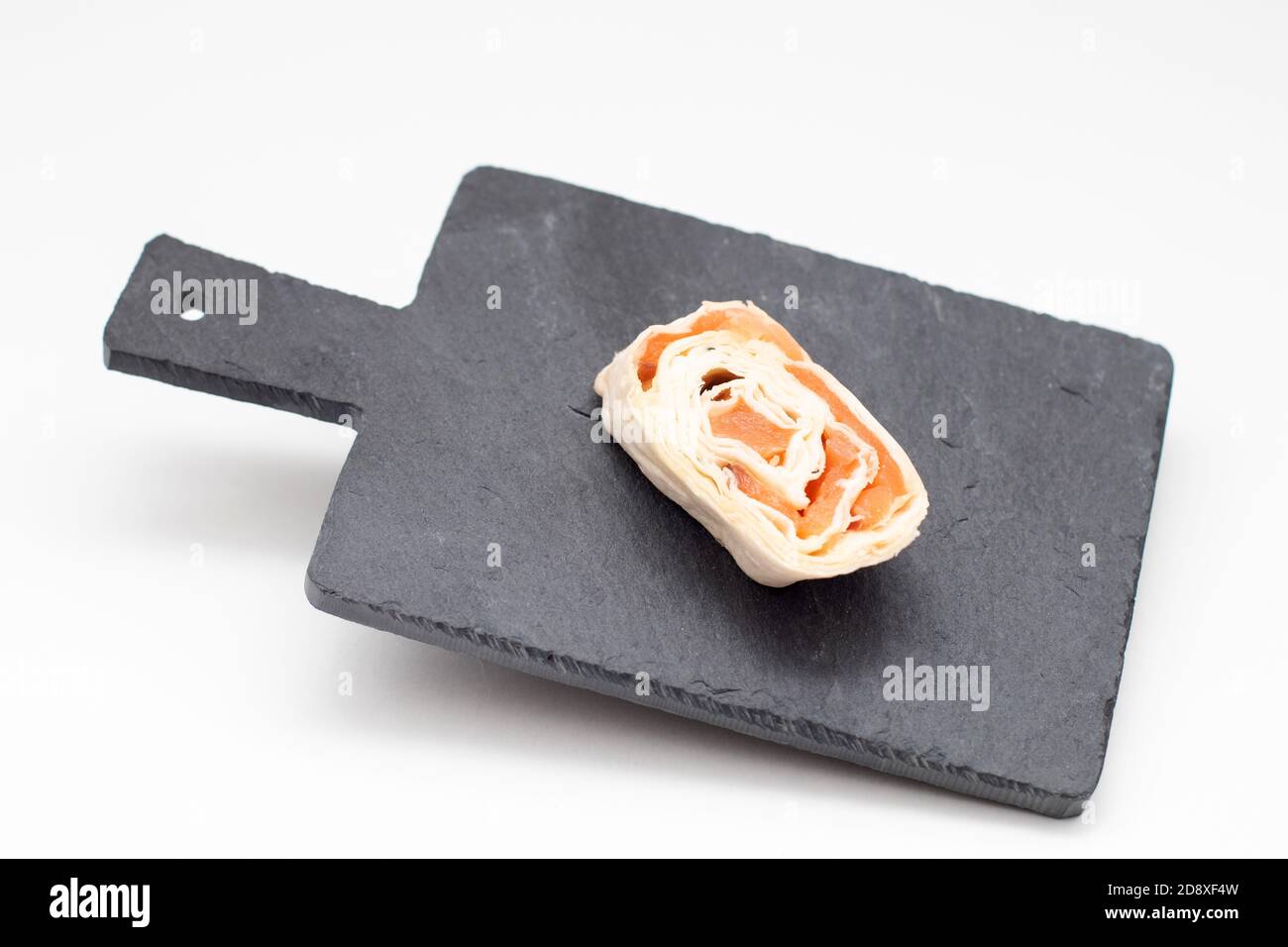Pfannkuchen Rolle Lachs auf schwebendem schwarzen Schieferbrett für Snack Stockfoto
