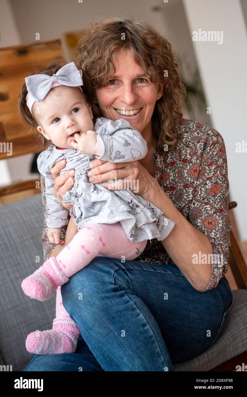 Oldenburg, Deutschland. September 2020. Ellen Matzdorf, Bestatter und Hebamme, sitzt mit Masha auf dem Sofa. (To dpa 'von Anfang bis Ende: Ellen Matzdorf ist Hebamme und Bestatter') Quelle: Sina Schuldt/dpa/Alamy Live News Stockfoto