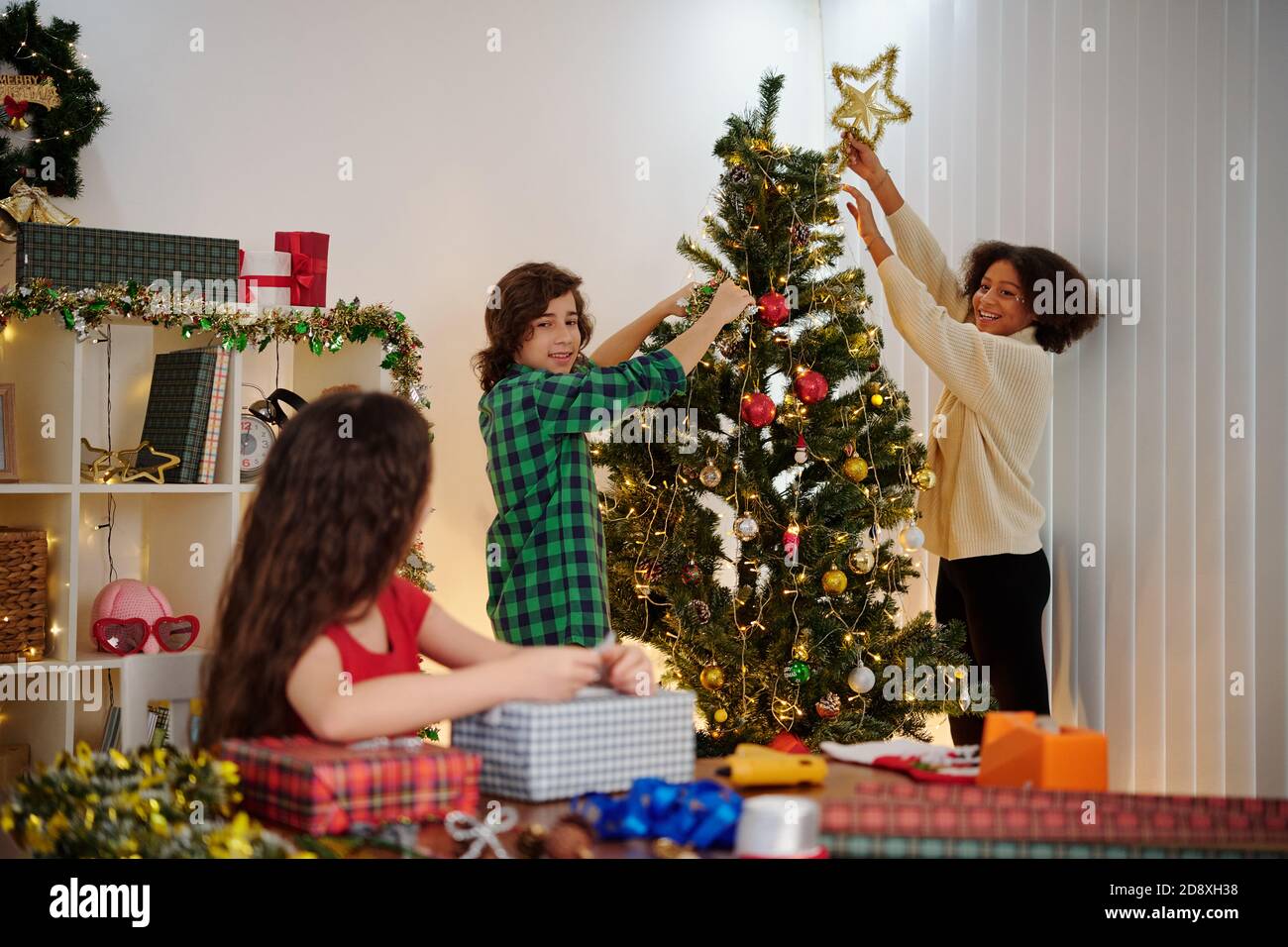 Kinder schmücken Weihnachtsbaum Stockfoto