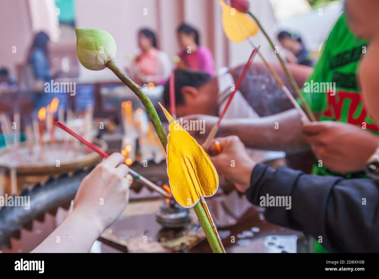 Asiatische buddhistische Anhänger halten Lotusblumen mit künstlichen goldenen heiligen Feigenblatt zu zahlen Respekt gegenüber buddha. Nahaufnahme. Stockfoto