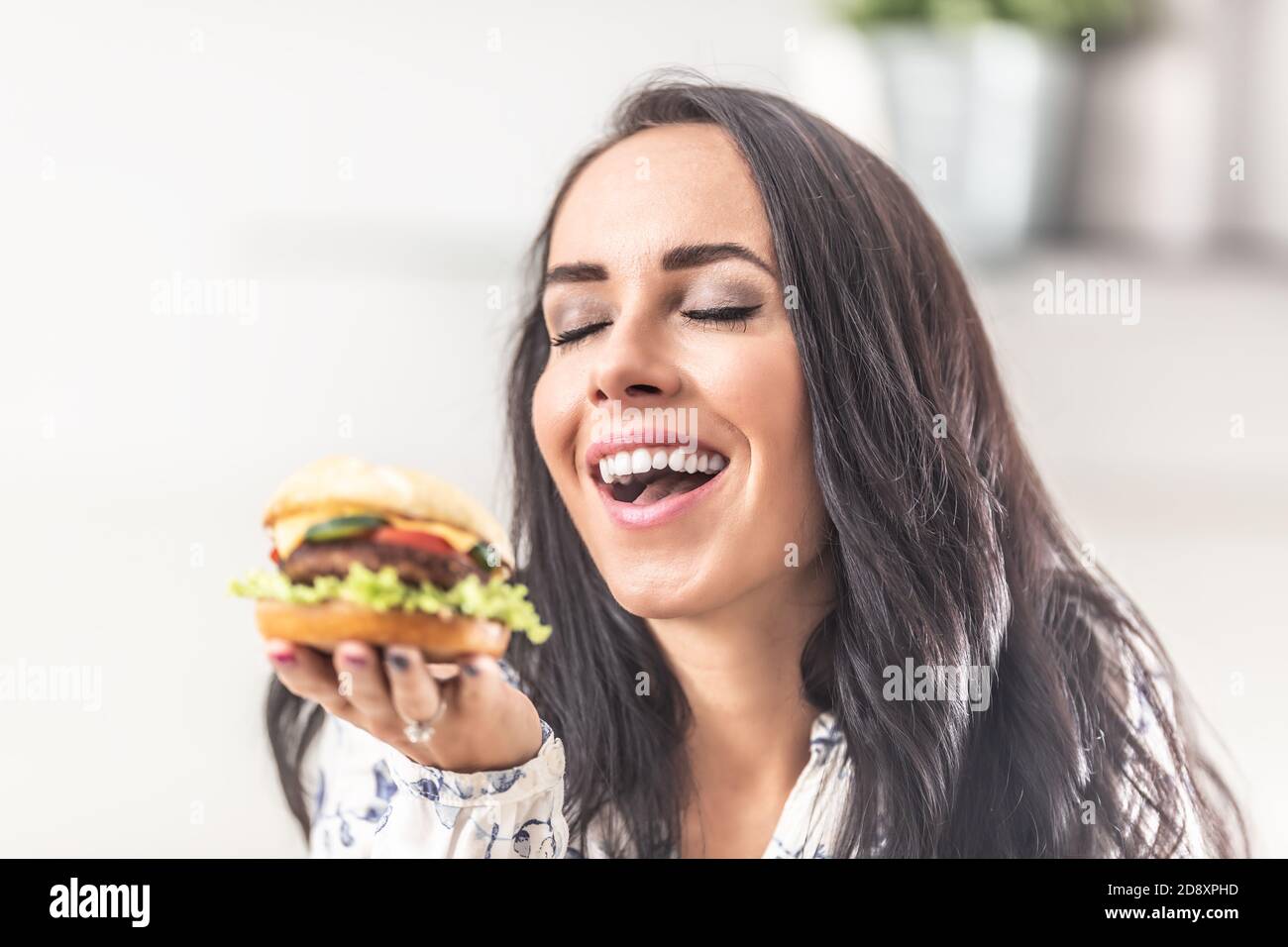 Mädchen genießt den Geruch eines frisch gekochten Burger in der Hand. Stockfoto