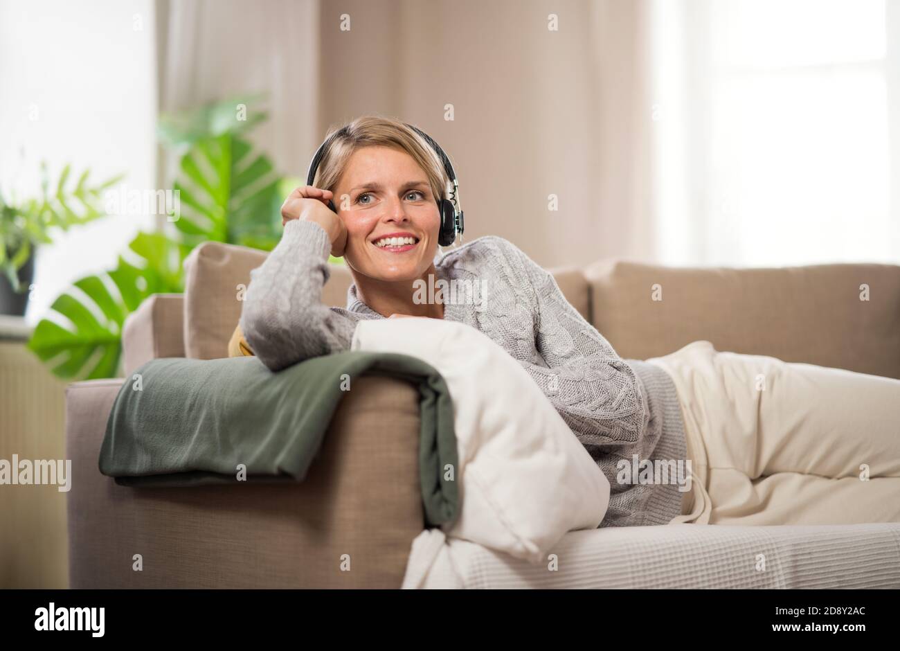 Portrait der Frau mit Kopfhörern Entspannung drinnen zu Hause, psychische Gesundheit Konzept. Stockfoto