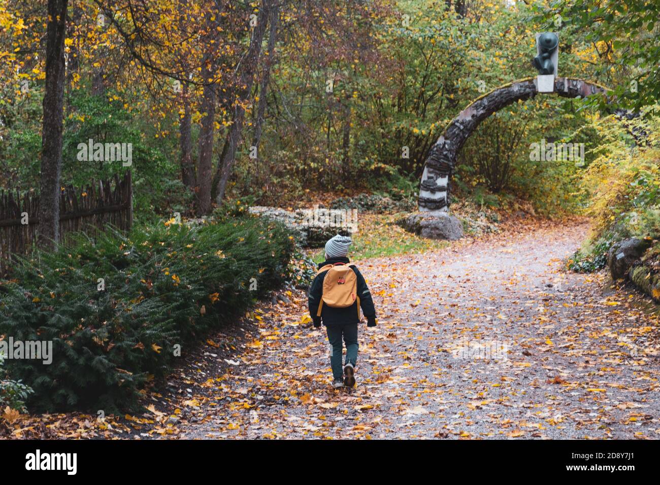 Kind mit Rucksack allein in der Natur im Wald im Herbst, Schule geschlossen wegen Covid oder Coronavirus Pandemie Stockfoto