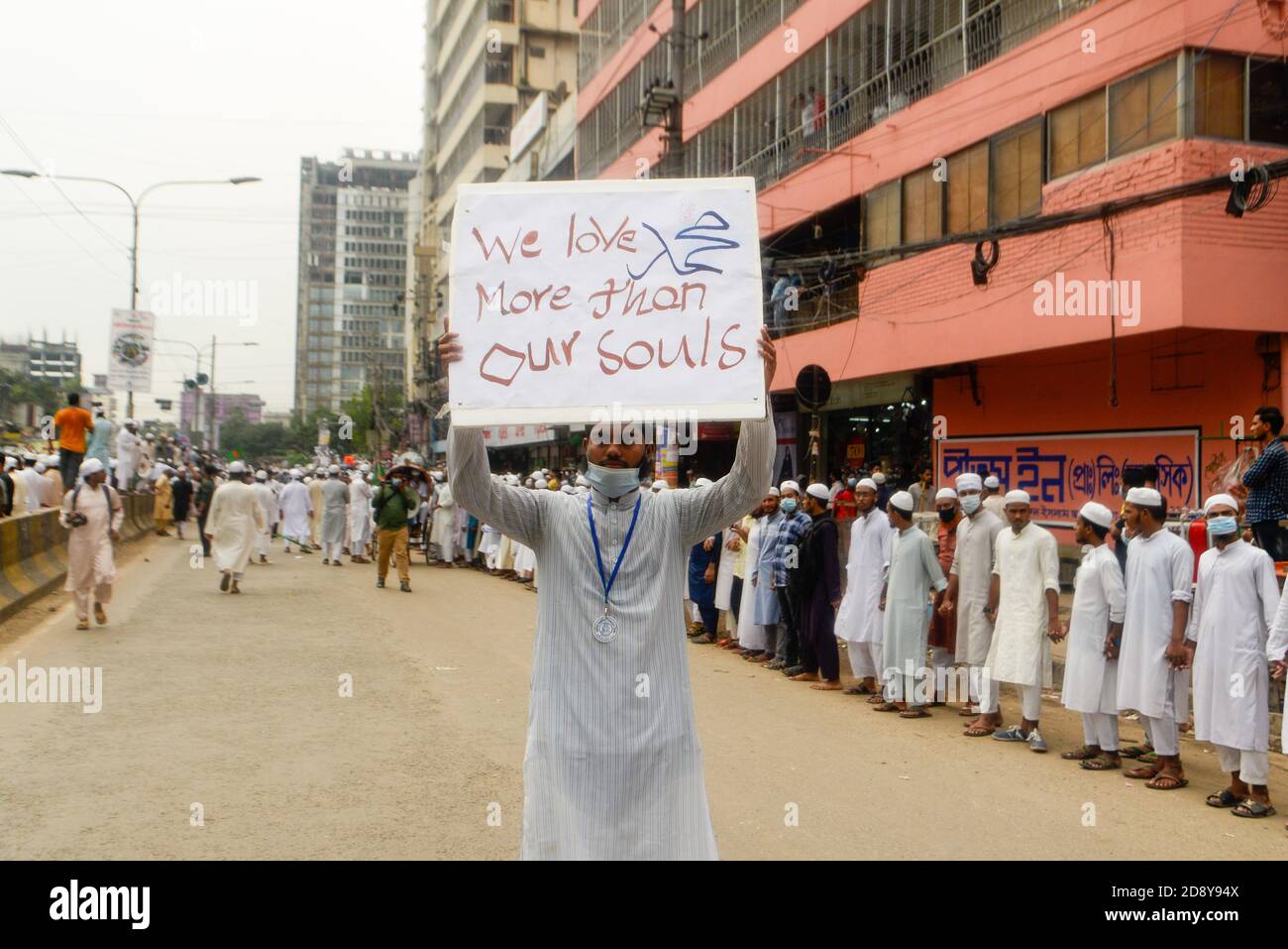 Ein Protestler einer islamistischen politischen Partei zeigt während des Protestes in Dhaka ein Plakat.Muslime protestieren zum Boykott französischer Produkte und verurteilen Präsident Emmanuel Macron für seine Kommentare über die Karikaturen des Propheten Mohammed. Stockfoto