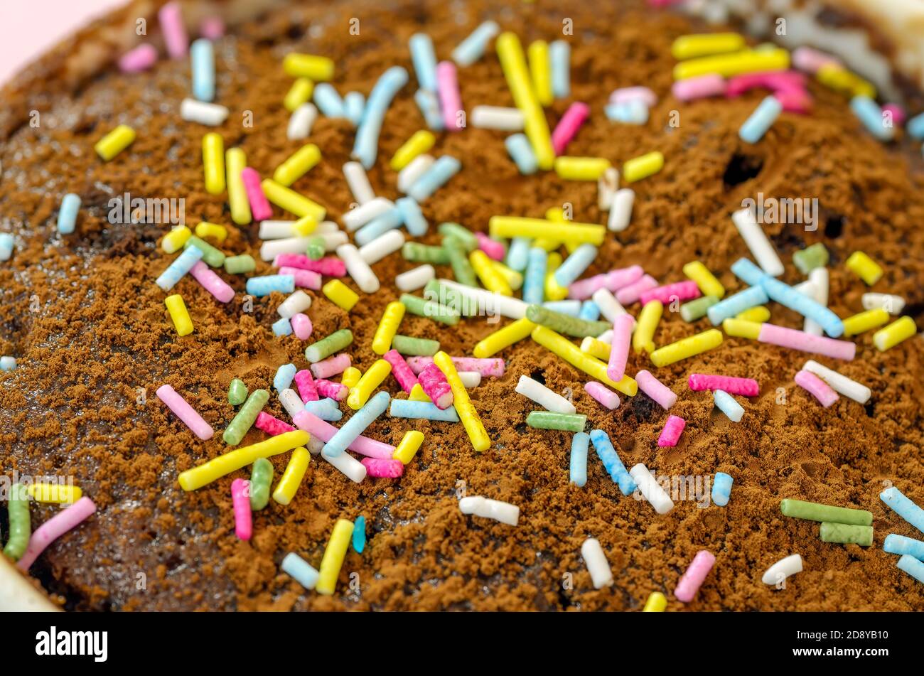 Bunte Zuckerstränge bestreut auf einem leckeren Schokoladenkuchen. Hintergrund Für Food Photography. Stockfoto