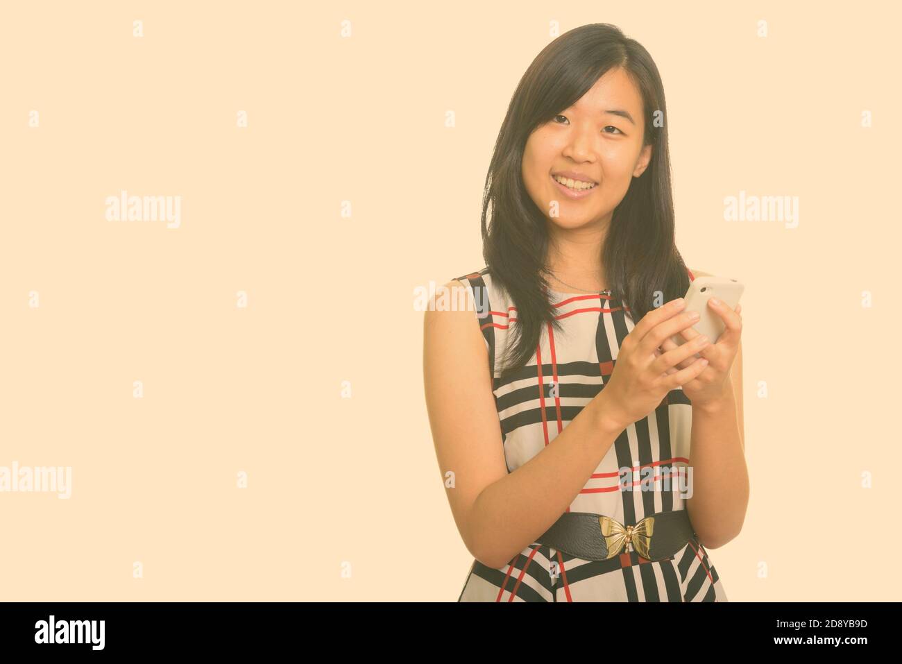 Junge gerne asiatische Geschäftsfrau holding Handy Stockfoto