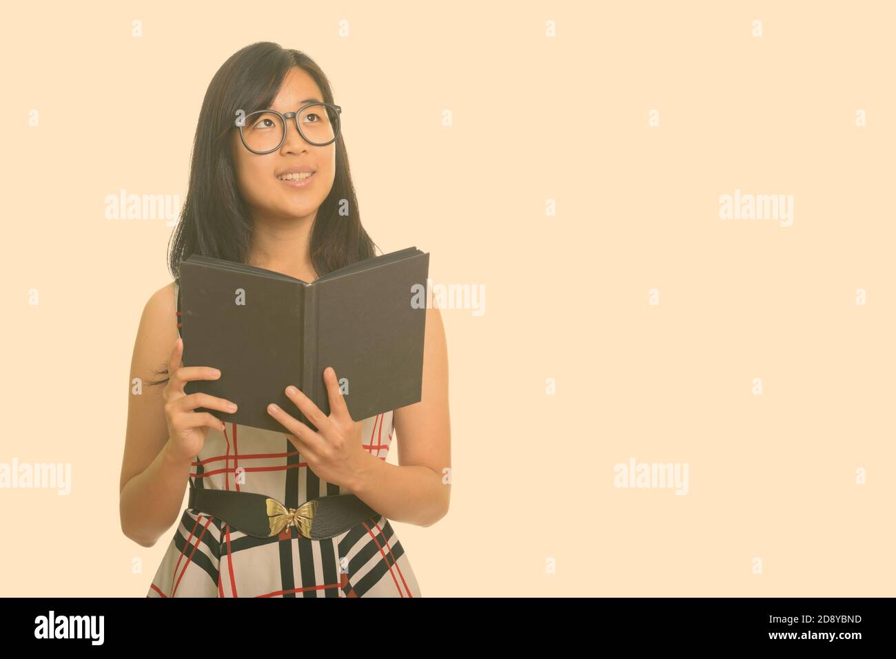 Junge gerne asiatische Geschäftsfrau holding Buch beim Denken Stockfoto
