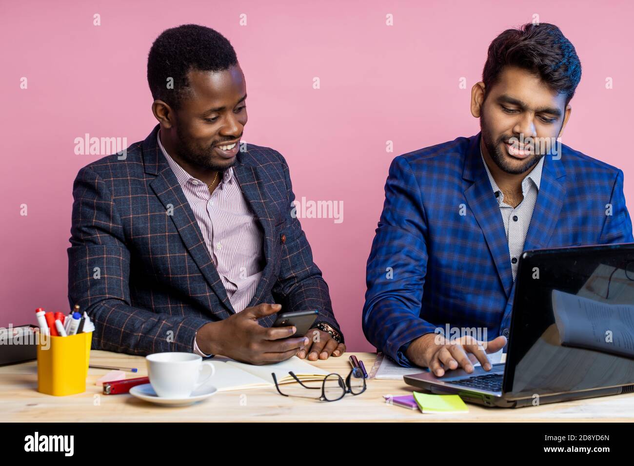 Schuss von zwei Geschäftsleuten, die Anzüge im Büro am Schreibtisch mit ...