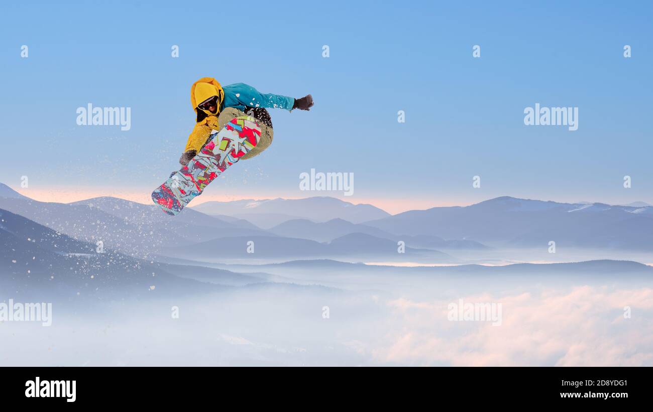 Snowboarder Jumping on Snowboard in den Bergen. Snowboarden und Wintersport Stockfoto