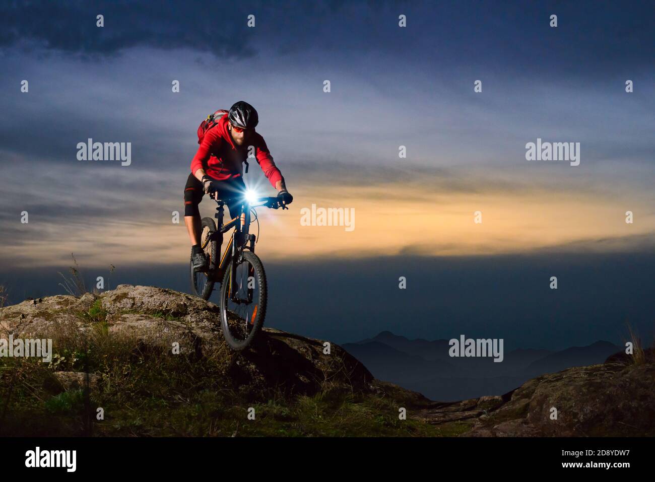 Radler mit dem Mountainbike auf dem Rocky Trail bei Nacht. Extreme Sport und Enduro Biking Konzept. Stockfoto