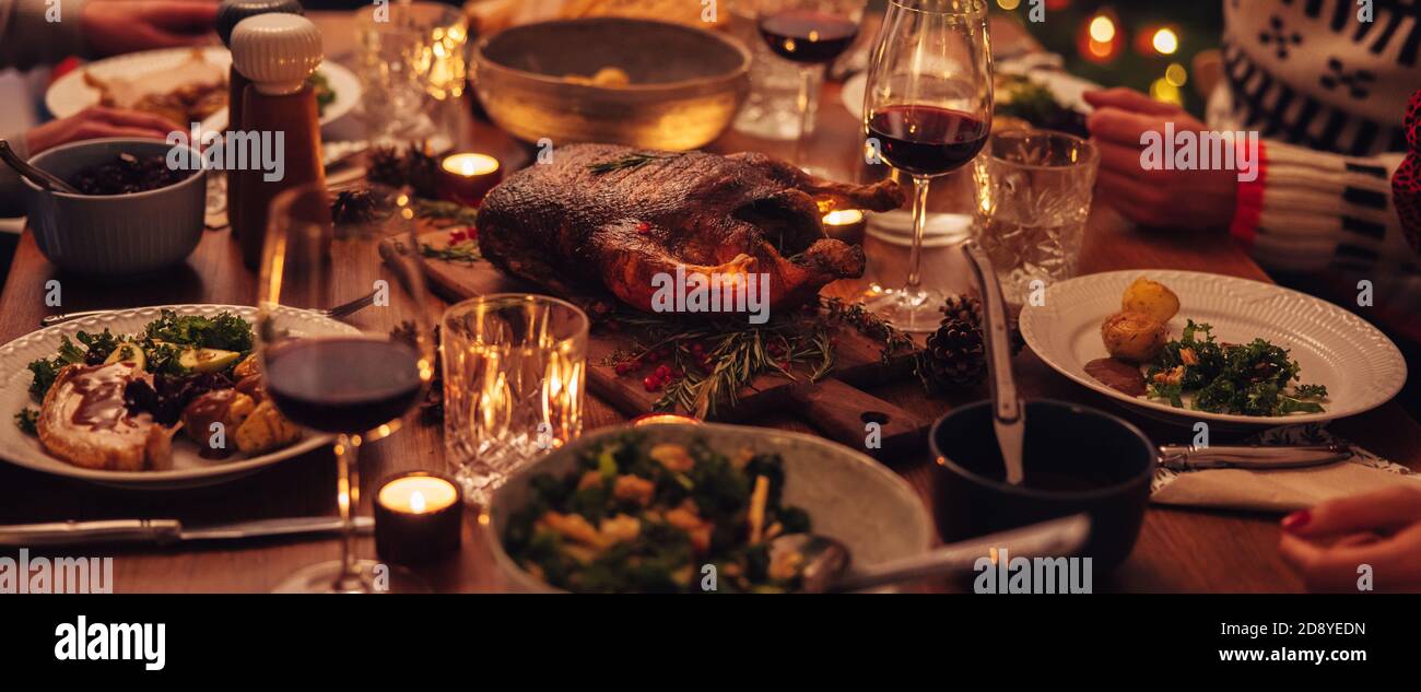 Tisch für Weihnachtsessen eingerichtet. Traditionelle gefüllte geröstete pute mit Wein auf dem Esstisch mit Familie herumsitzen. Stockfoto