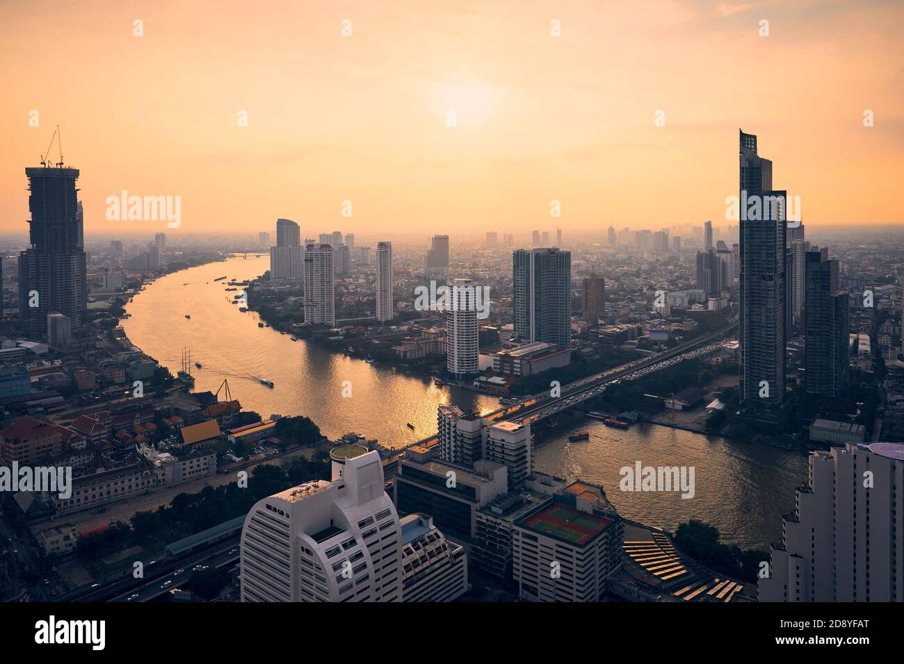 Städtische Skyline Bangkok bei Sonnenuntergang. Wolkenkratzer in der Nähe des Chao Phraya Flusses, Thailand. Stockfoto