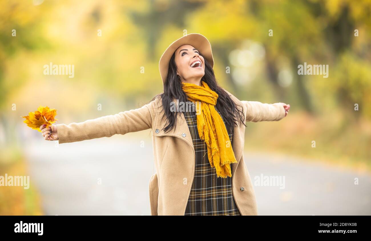 Glückliche Frau genießen Zeit im Freien halten Orangenbaum Blätter in der bunten Natur. Stockfoto