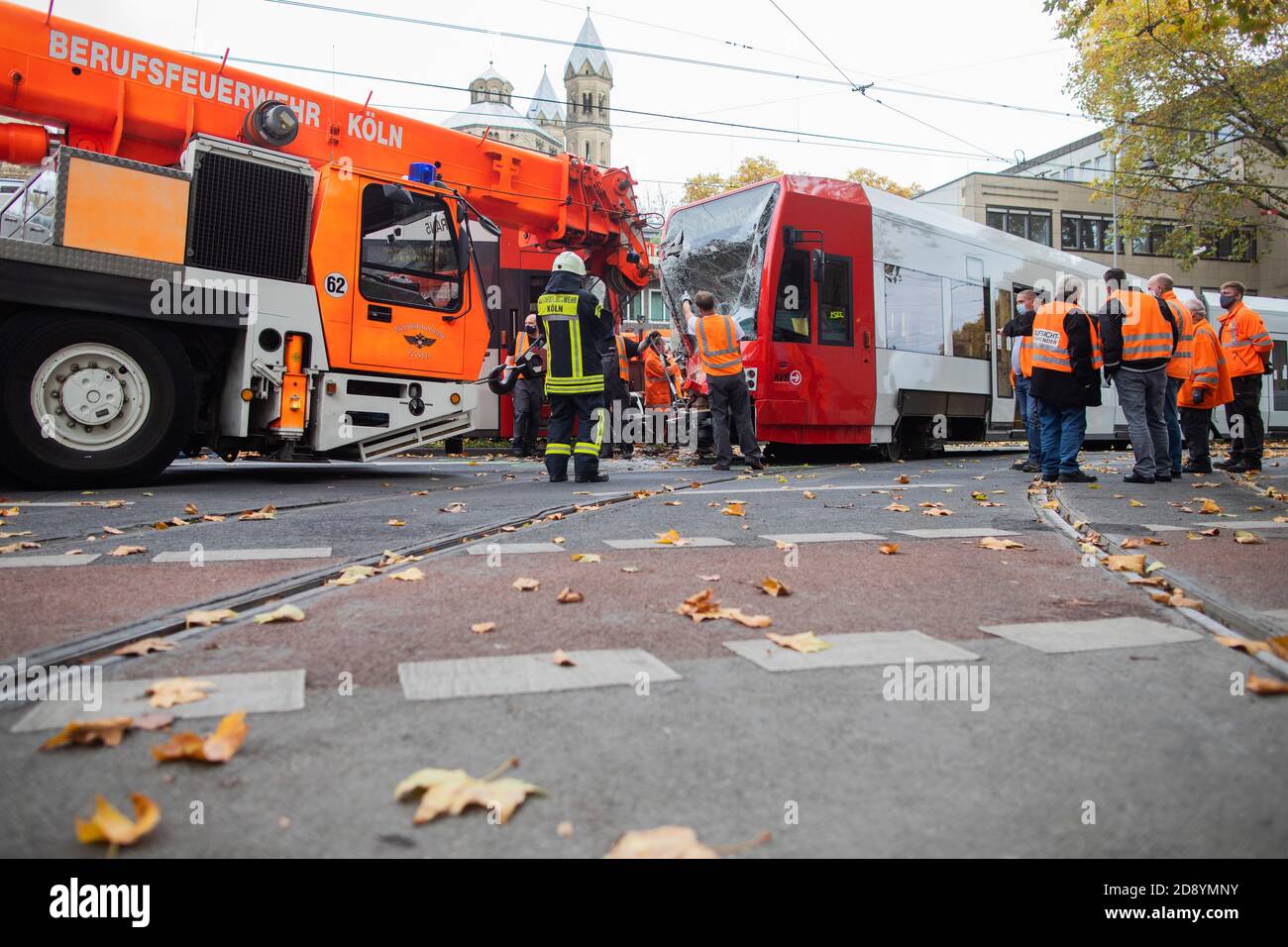 Köln, Deutschland. November 2020. Eine Straßenbahn wird nach einer Kollision am Neumarkt von einem Kran in das Gleisbett gehoben. Mindestens 20 Menschen wurden bei dem Frontalzusammenstoß der beiden Straßenbahnen verletzt. Dabei handelt es sich um leicht verletzte Fahrgäste und die beiden Straßenbahnfahrer, die nach Angaben der Polizei schwere Verletzungen erlitten haben. Quelle: Rolf Vennenbernd/dpa/Alamy Live News Stockfoto