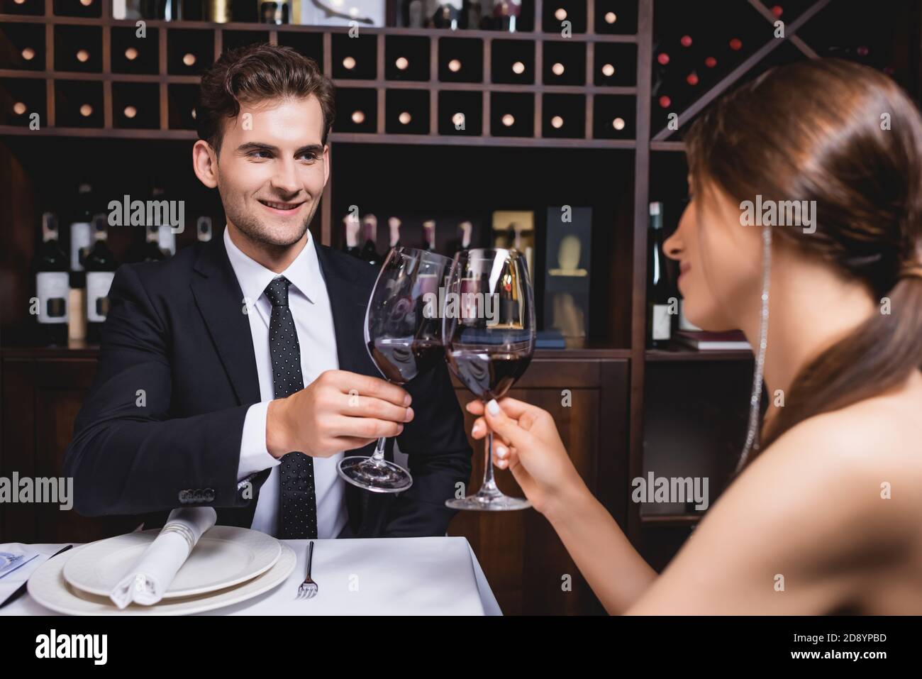 Selektiver Fokus des jungen Paares klirren Gläser Wein während Dating im Restaurant Stockfoto