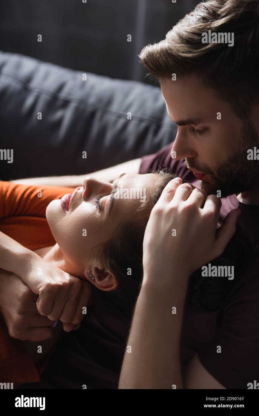 Zärtlicher Mann berührt den Kopf der geliebten Frau und beruhigt sie Zu Hause Stockfoto