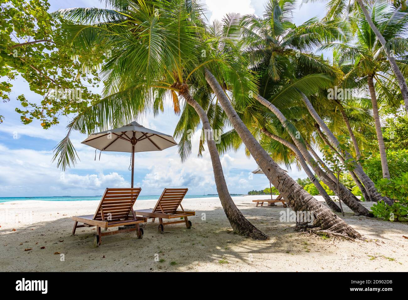 Zwei Liegen am idyllischen, tropischen, weißen Sandstrand. Schatten von den Palmen. Kein Rauschen, sauberes, extrem detailliertes 3d-Rendering. Konzept für Urlaub Stockfoto